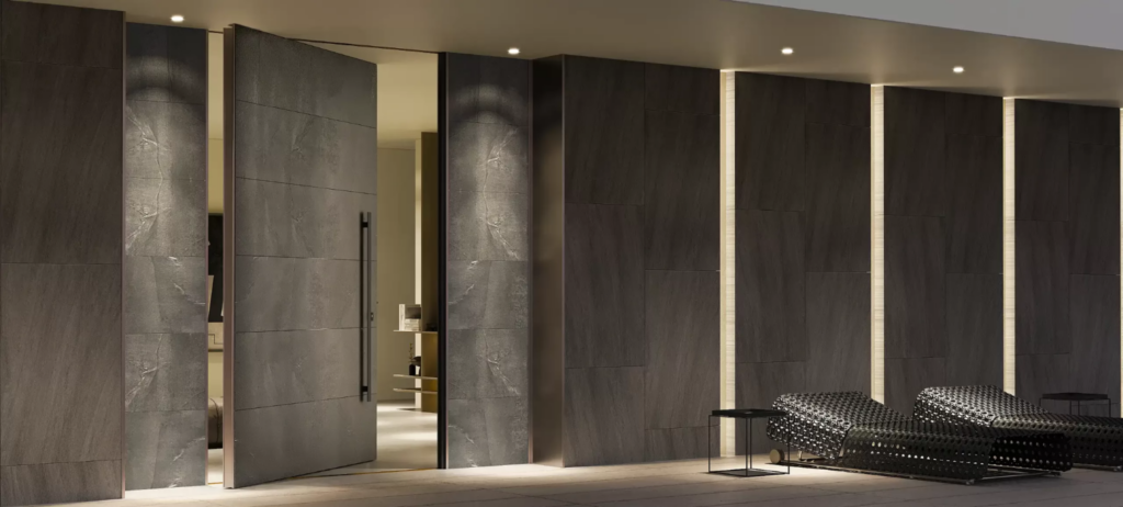 Puerta pivotante ICA Porte con revestimiento oscuro, integrada en una pared con iluminación vertical